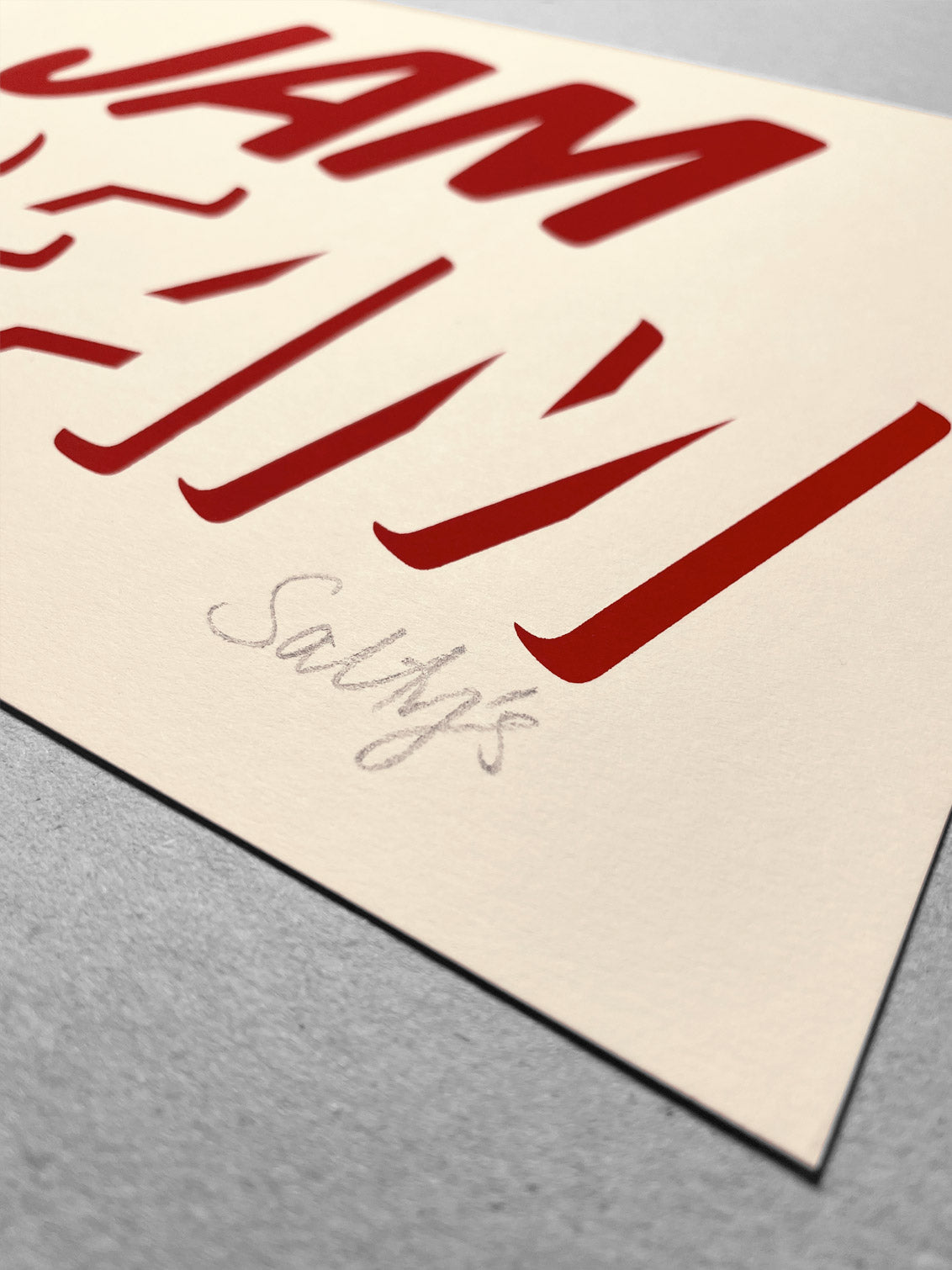 Close up of cleanly printed type in strawberry red ink on a cream coloured recycled card stock, reading CREAM across the bottom with JAM written on top! Salty’s pencil signature in the bottom right corner.