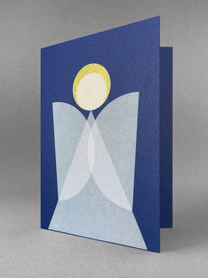 Geometric angel design, blue card, white overlapping wings and a gold halo. Sits in a light grey studio